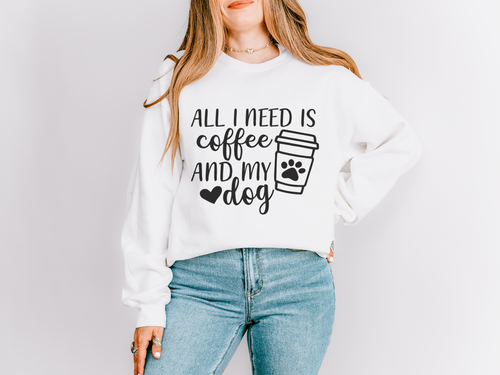 Woman wearing a white sweatshirt that reads All I need is coffee and my dog with a paw print