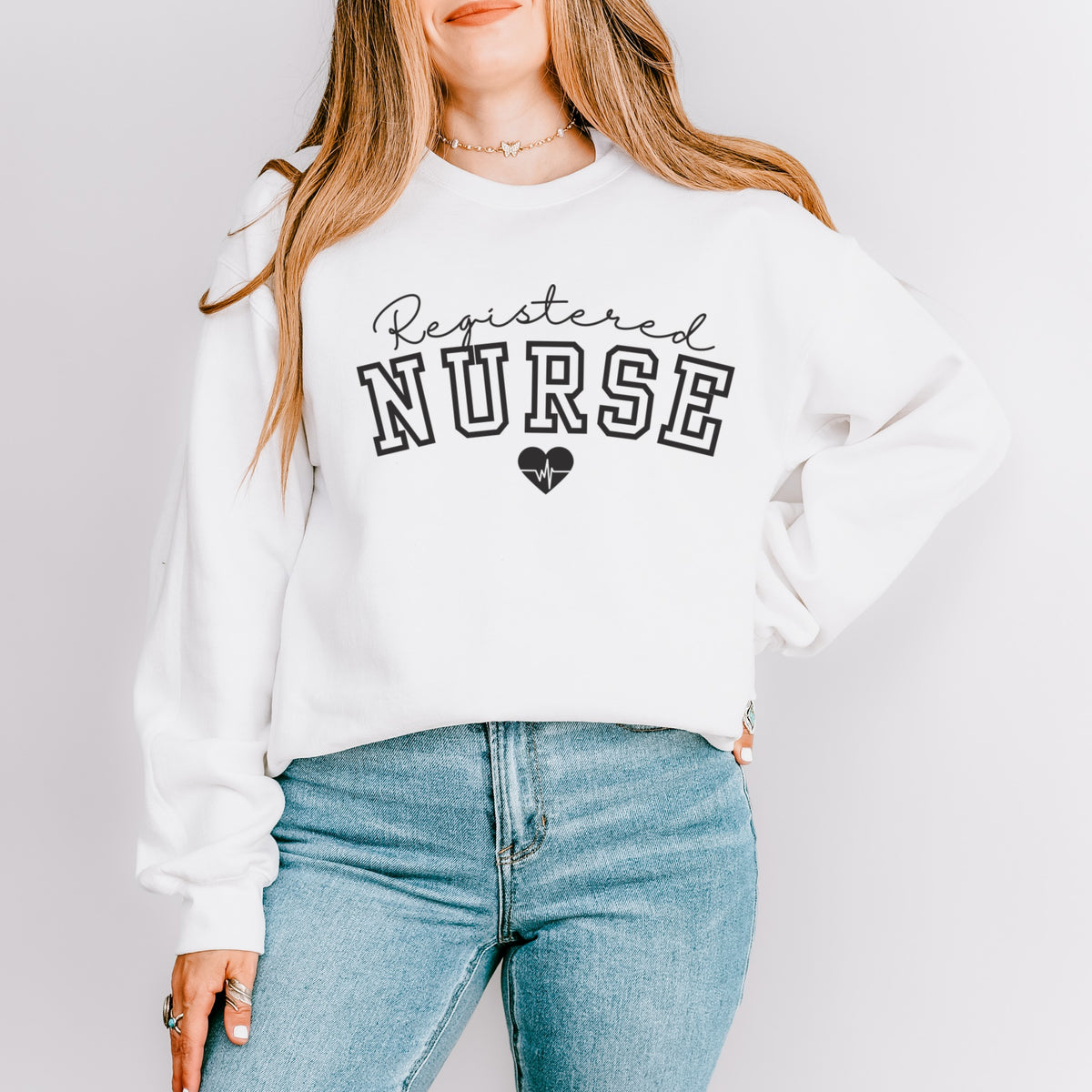 White crewneck sweatshirt that reads Registered Nurse with a heartbeat heart