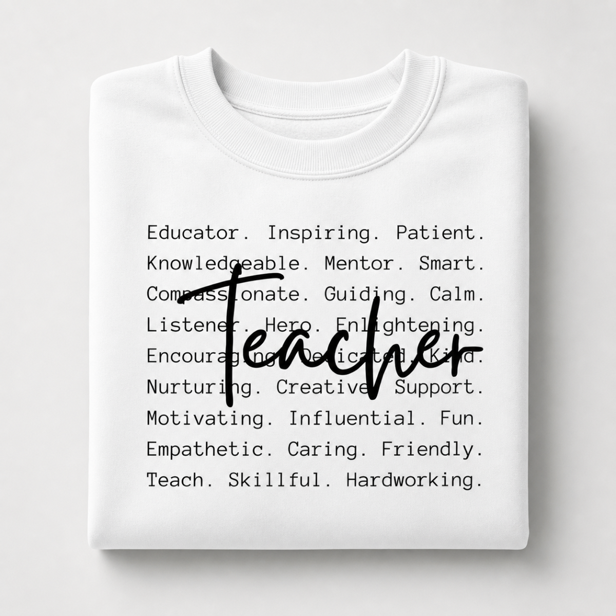 White folded crewneck sweatshirt with teacher qualities and Teacher in script