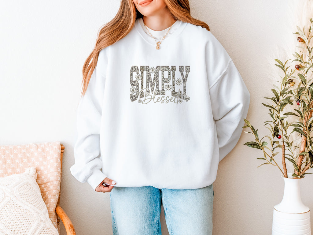 Woman wearing a white crewneck sweatshirt that reads Simply Blessed